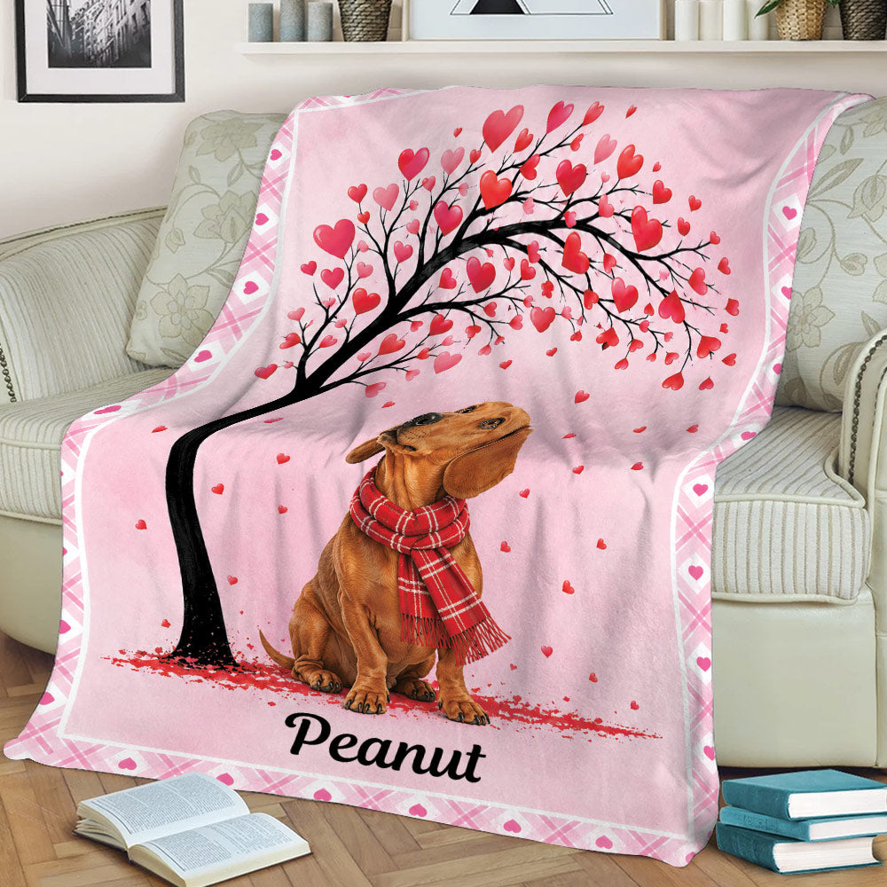 Pink dachshund throw blanket draped over a sofa with heart-covered tree artwork