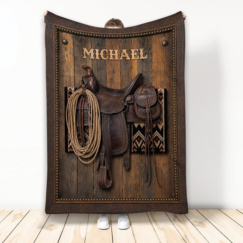 Cowboy throw blanket featuring a Western saddle, coiled rope, wood texture and rustic leather-style border
