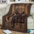 Rustic cowboy throw blanket draped over a sofa with saddle, rope and Western tack artwork