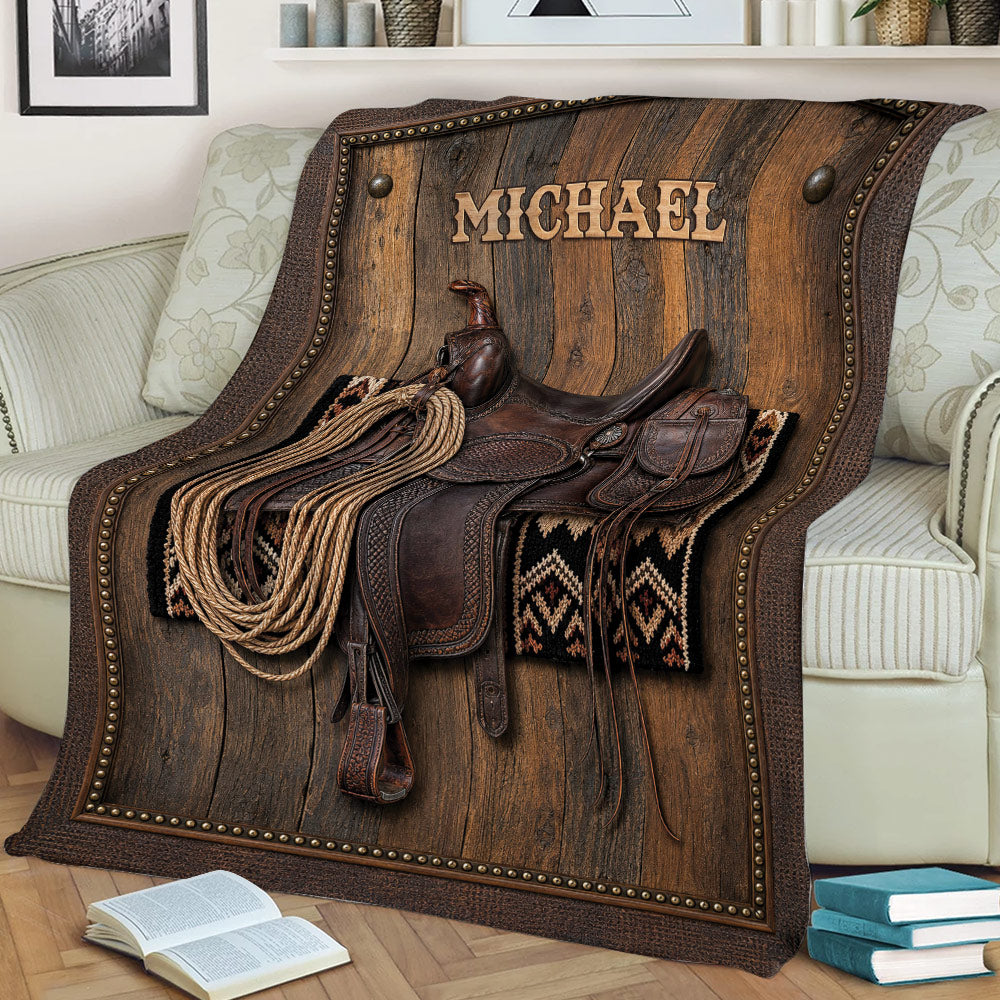 Rustic cowboy throw blanket draped over a sofa with saddle, rope and Western tack artwork