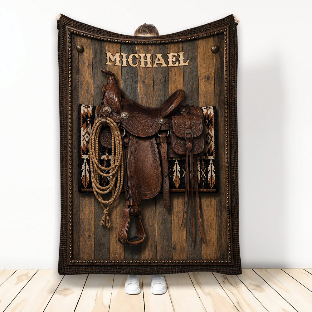 Cowboy blanket featuring a Western saddle, coiled rope, leather tack, wood plank background, and Southwestern pattern