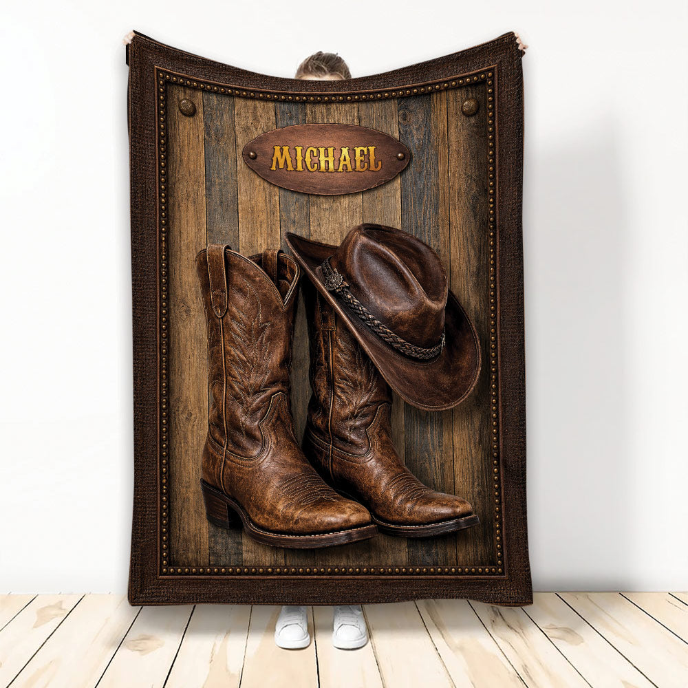 Cowboy blanket featuring a leather-look hat and Western boots on a rustic wood background
