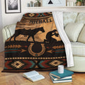 Cowboy blanket displayed on a sofa with horse silhouette, horseshoe artwork, and rustic Southwestern patterns