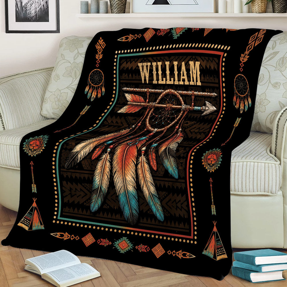 American Native throw blanket displayed on a sofa with a large dreamcatcher, feathers, arrows, and geometric motifs