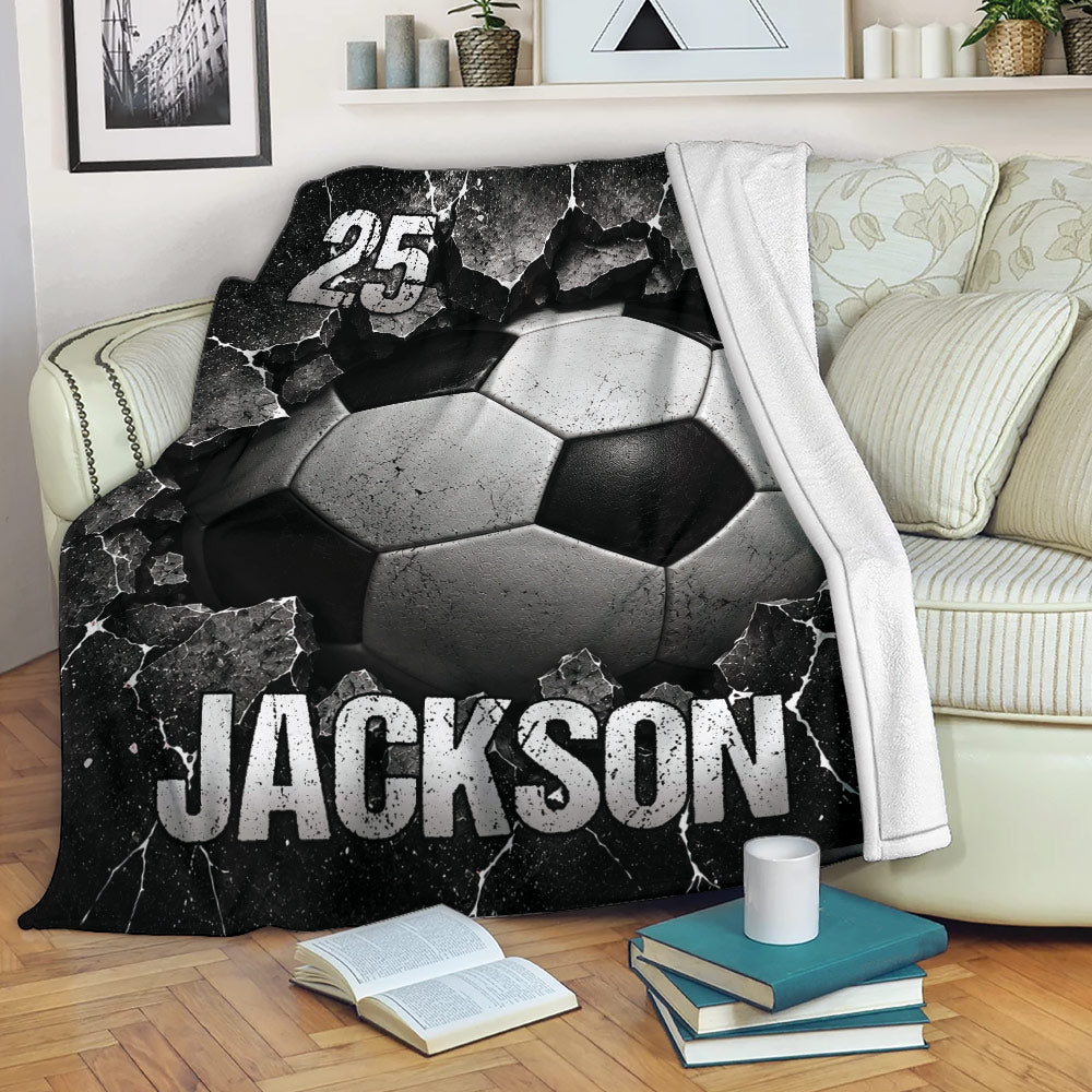 Cracked black and white soccer ball blanket draped over a living room sofa