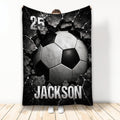 Black and white soccer ball breaking through a cracked surface on a dramatic sports blanket