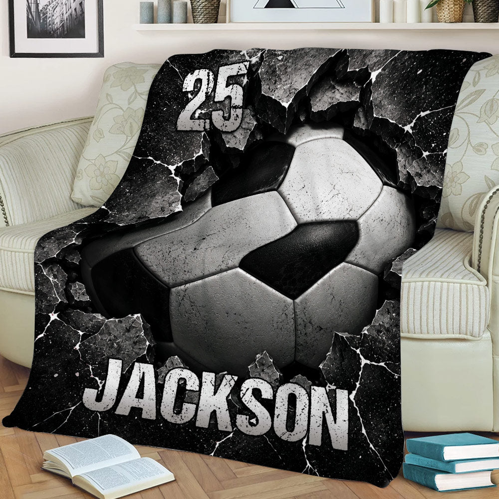 Dramatic soccer ball artwork on a black and white throw blanket displayed on a couch