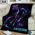 Black hockey throw blanket draped over a couch with dynamic skating player artwork