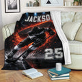 Hockey throw blanket draped over a sofa, showing dynamic ice hockey artwork in black, white, and vivid red