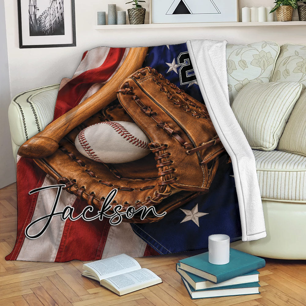 Baseball blanket draped over a sofa with glove, bat, baseball, and patriotic stars and stripes design