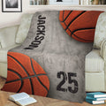 Close view of a basketball throw blanket draped across a sofa with sports-inspired artwork
