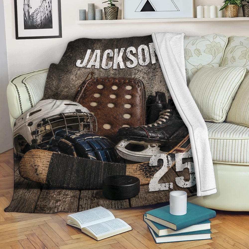 Hockey blanket draped over a sofa with rustic equipment artwork and sports-themed room decor