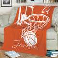 Orange basketball throw blanket displayed on a couch with large hoop and ball artwork