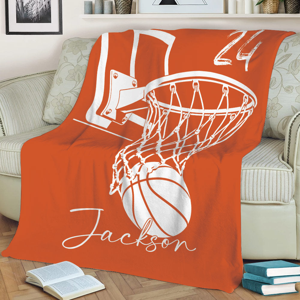 Orange basketball throw blanket displayed on a couch with large hoop and ball artwork