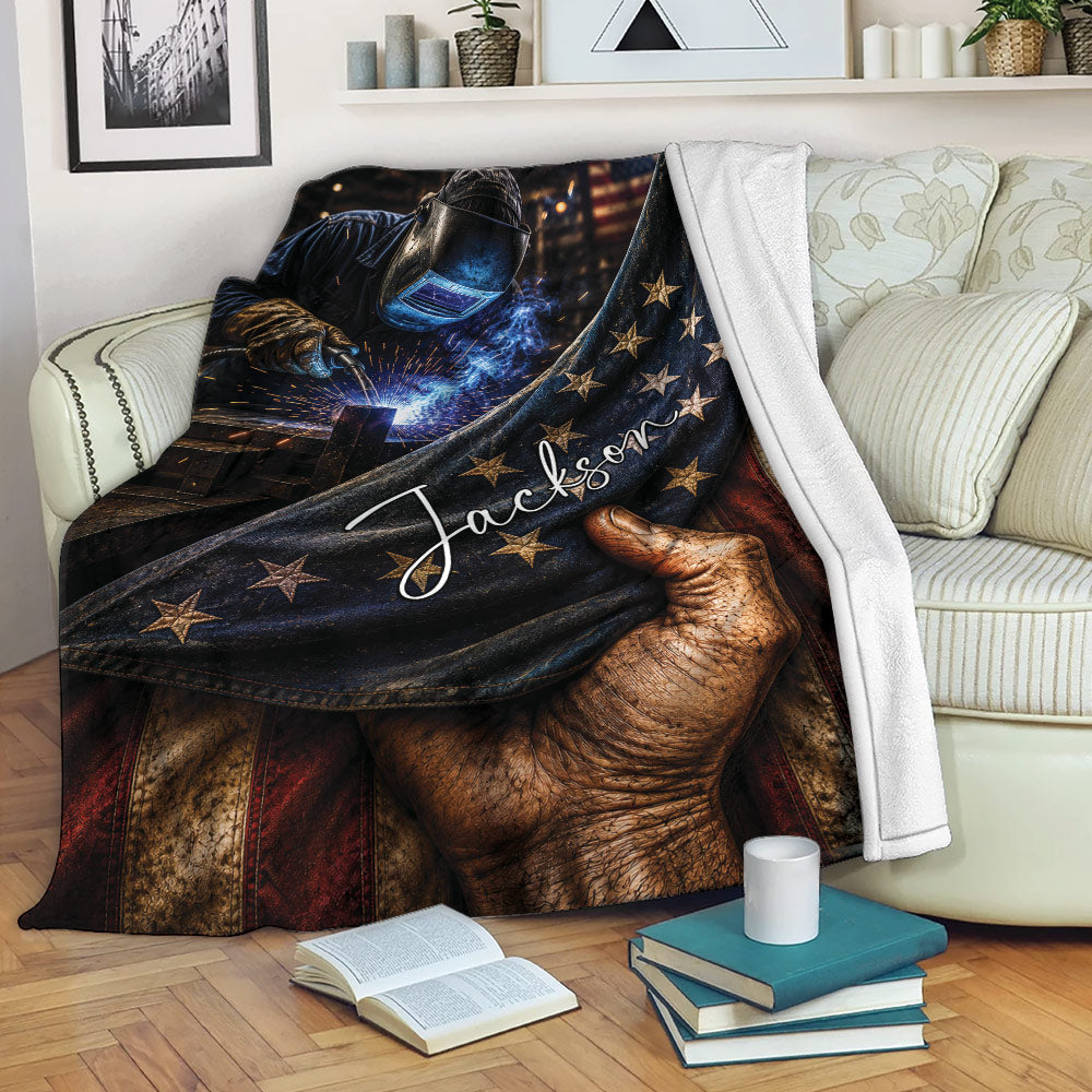 Custom welder blanket draped over a sofa with welding sparks, protective gear, stars, and rustic patriotic artwork