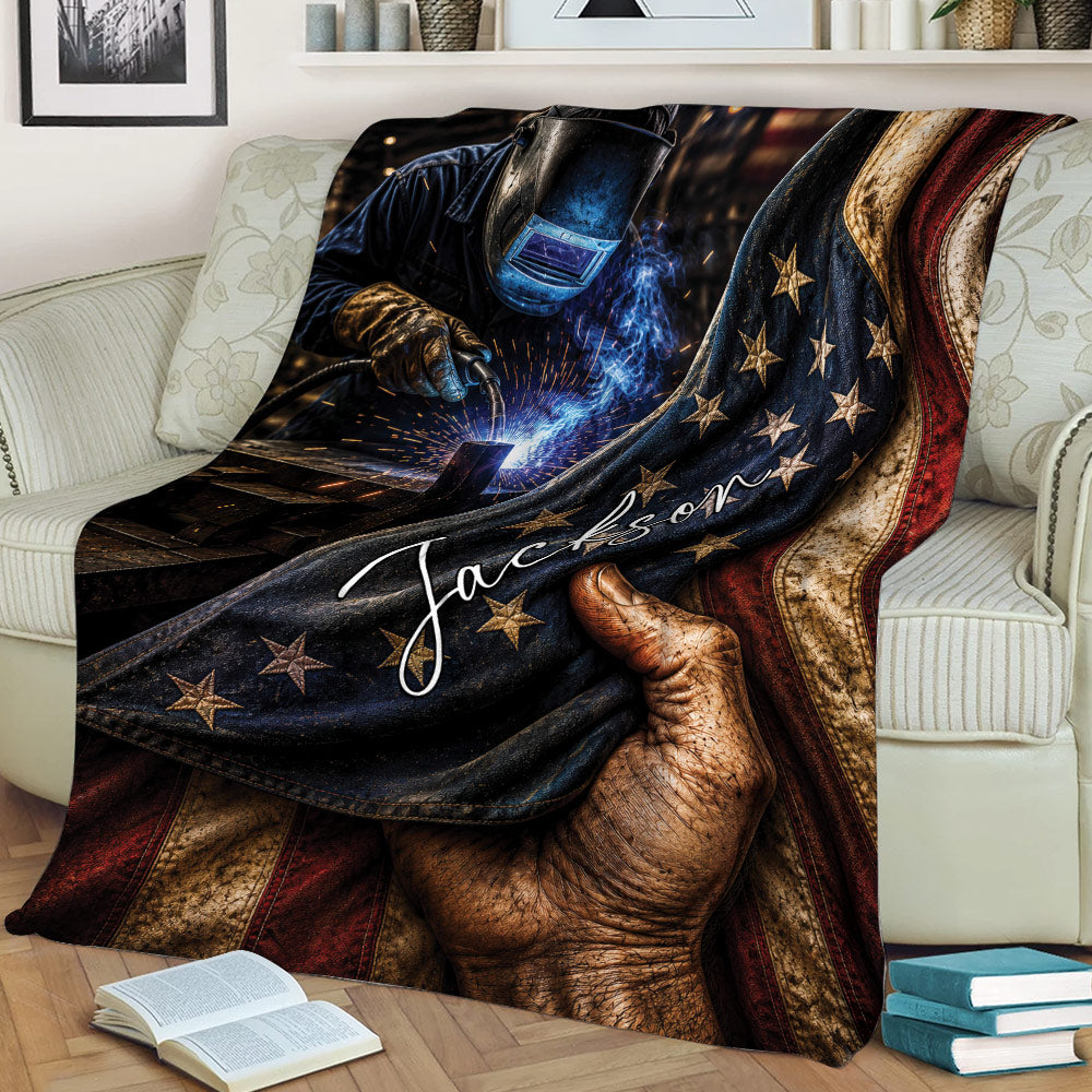 Welder throw blanket displayed on a couch with welding equipment, glowing sparks, stars, and bold flag-inspired colors