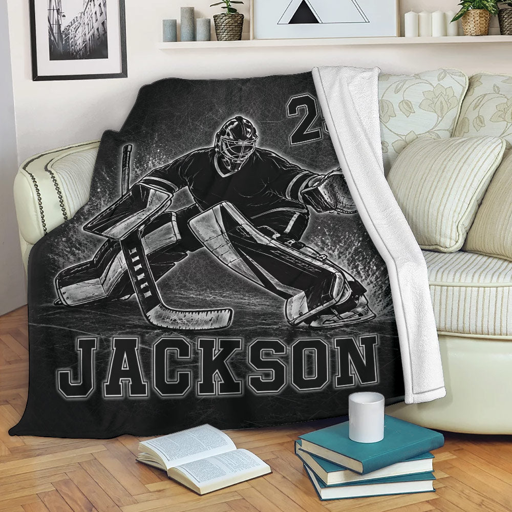 Black hockey goalie throw blanket styled on a cozy living room sofa