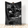 Black and white hockey throw blanket featuring ice hockey skates, a stick, puck, and woodgrain sports artwork