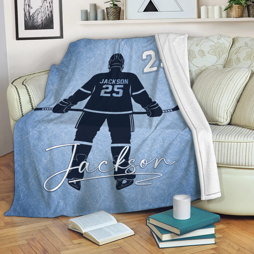 Custom hockey throw blanket displayed on a sofa with icy blue player artwork