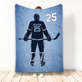 Blue hockey blanket featuring an ice hockey player silhouette with stick and skates