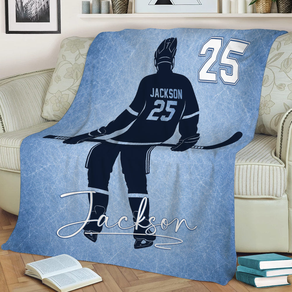 Ice hockey player throw blanket styled on a couch with blue rink-inspired artwork