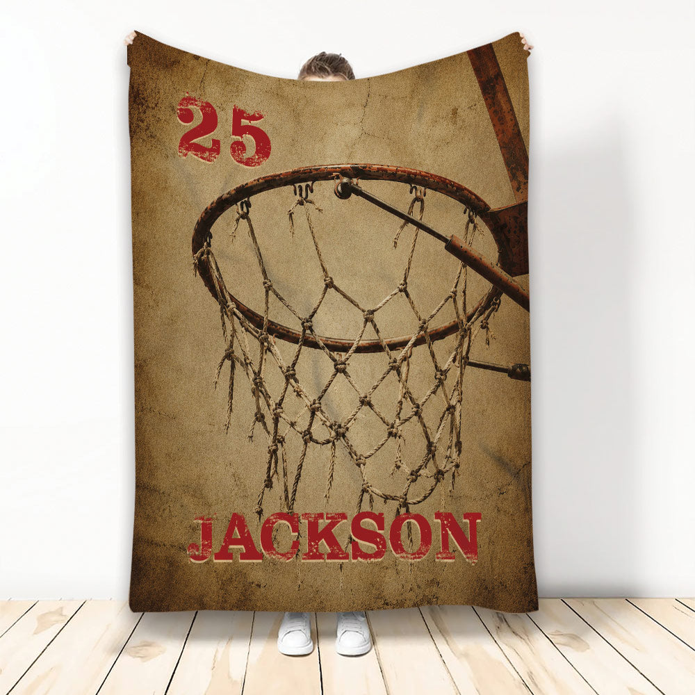 Basketball throw blanket with vintage sepia hoop and net artwork displayed against a wall