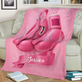 Breast cancer awareness throw blanket with pink boxing gloves and ribbon artwork on a couch
