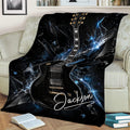 Black electric guitar blanket displayed on a sofa with dramatic blue abstract artwork
