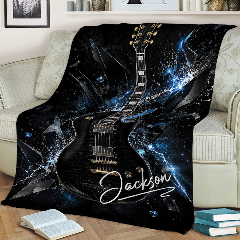 Black electric guitar blanket displayed on a sofa with dramatic blue abstract artwork