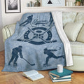 Blue hockey blanket styled on a sofa with illustrated players, crossed sticks, puck, and distressed sports design