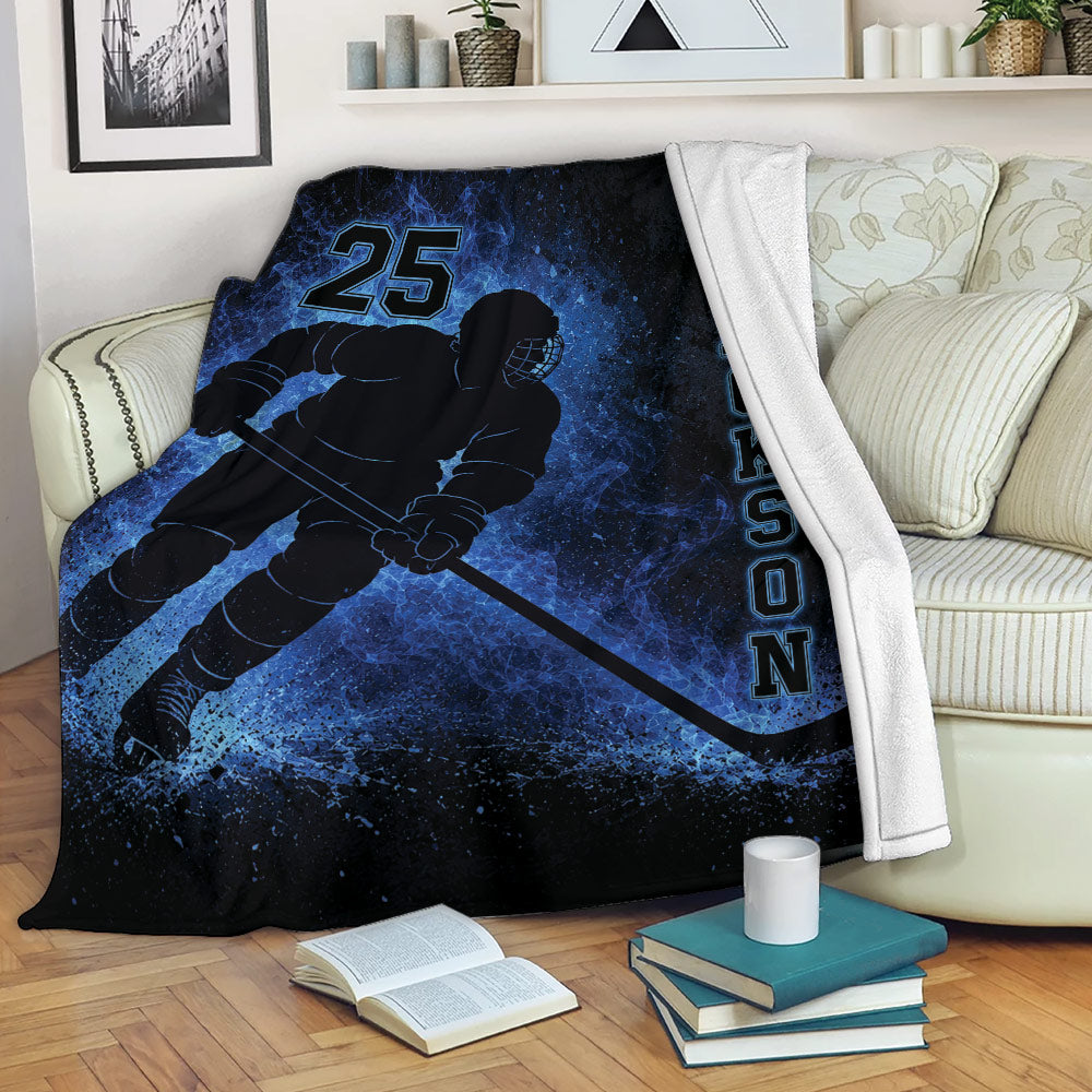 Blue ice hockey throw blanket draped over a sofa with a helmeted player and hockey stick design