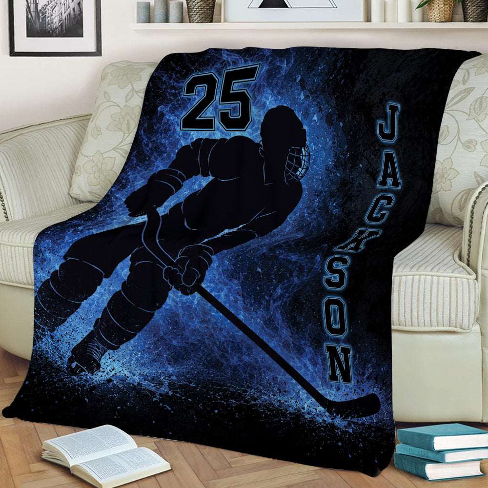 Hockey throw blanket displayed on a couch with dramatic blue ice-inspired artwork and player silhouette