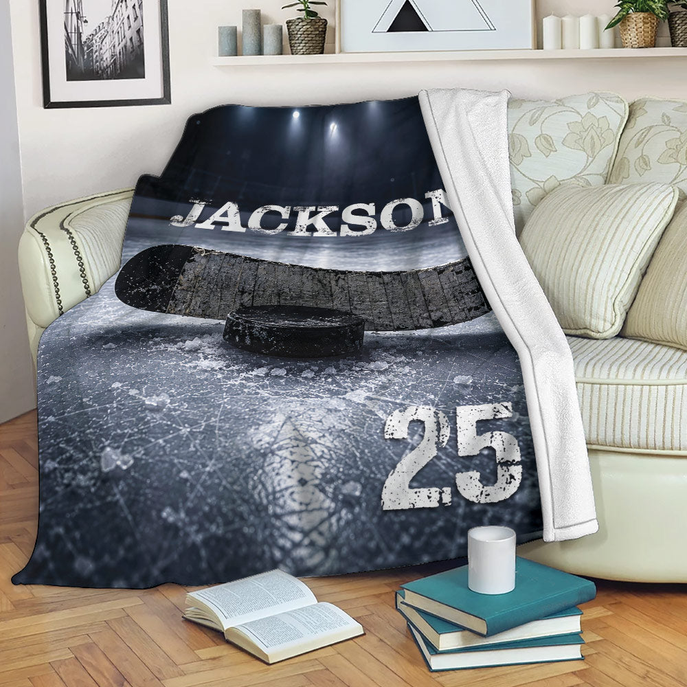 Hockey blanket draped over a sofa with ice rink artwork, hockey stick, and puck design