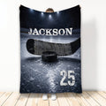 Hockey throw blanket displayed with a hockey stick, puck, ice rink artwork, and dark arena lighting
