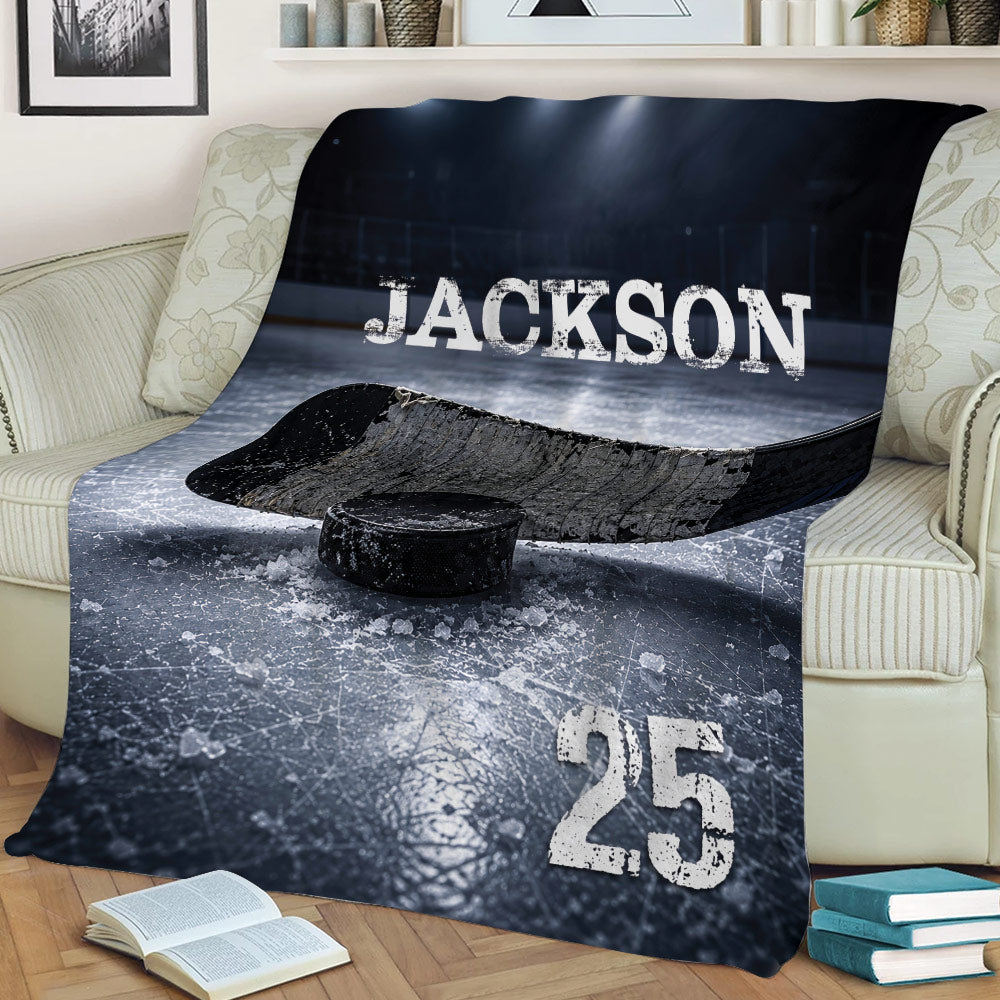 Hockey throw blanket styled on a sofa with dramatic ice rink, stick, and puck artwork