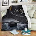 Hockey throw blanket styled on a sofa with hockey stick and puck artwork