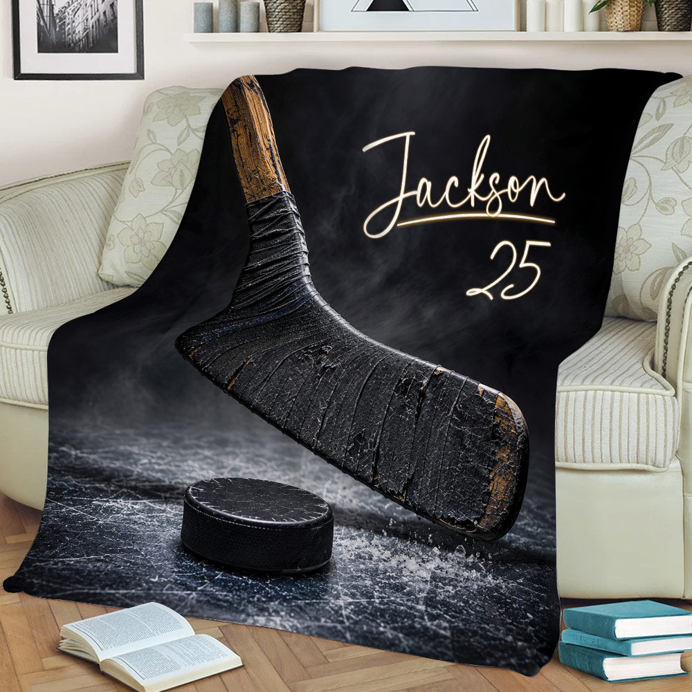 Hockey blanket draped over a couch featuring bold stick, puck, and ice rink artwork