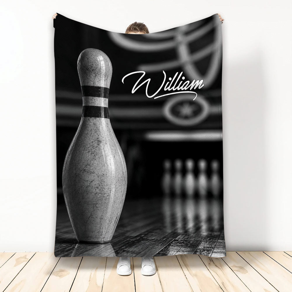 Black and white bowling throw blanket displayed vertically with a large bowling pin and bowling alley artwork