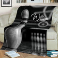 Bowling throw blanket styled on a sofa with bowling pin artwork, lane reflections, and bowling pins in the background
