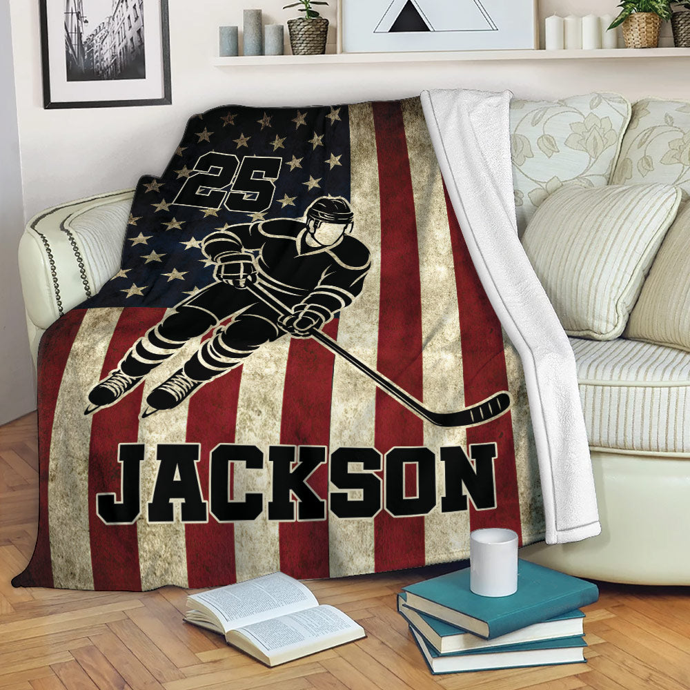 Patriotic hockey throw blanket draped over a sofa with star-spangled player artwork and bold red stripes