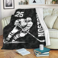 Hockey throw blanket draped over a sofa, showing a monochrome player and black camouflage design