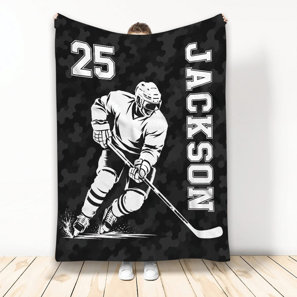 Black camouflage hockey throw blanket featuring a monochrome ice hockey player skating with a stick