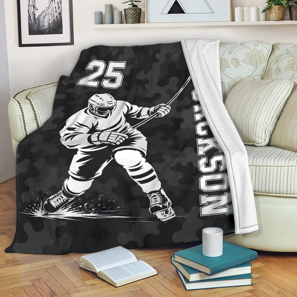 Hockey throw blanket draped over a couch with black camouflage sports artwork