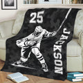 Black camouflage throw blanket displayed on a sofa with bold hockey player artwork