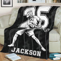 Black lacrosse throw blanket draped over a couch with dynamic player artwork and strong monochrome sports design