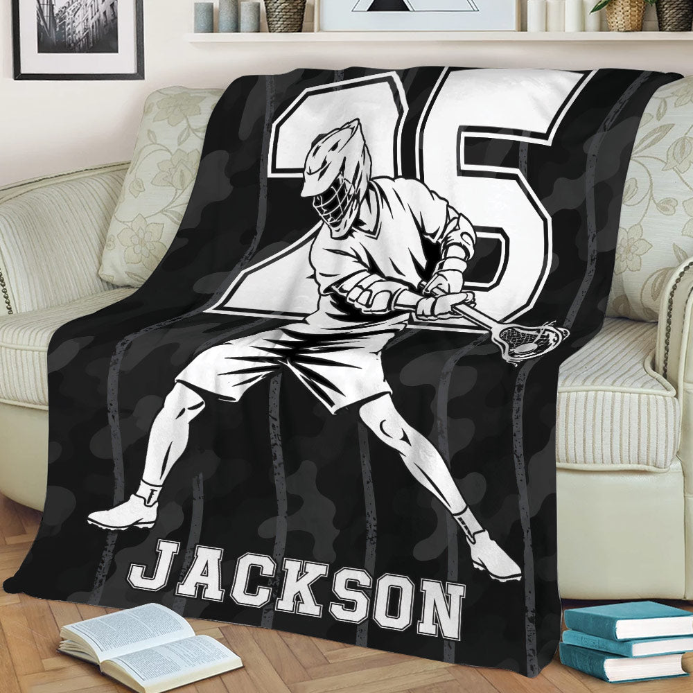 Black lacrosse throw blanket draped over a couch with dynamic player artwork and strong monochrome sports design