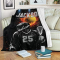 Lacrosse throw blanket displayed on a sofa with a helmeted player, lacrosse stick, and fiery sports artwork