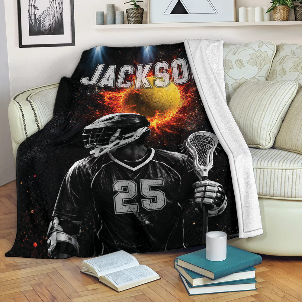 Lacrosse throw blanket displayed on a sofa with a helmeted player, lacrosse stick, and fiery sports artwork