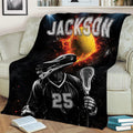 Lacrosse throw blanket styled on a couch, featuring a helmeted player, stick, ball, and bold black and red design