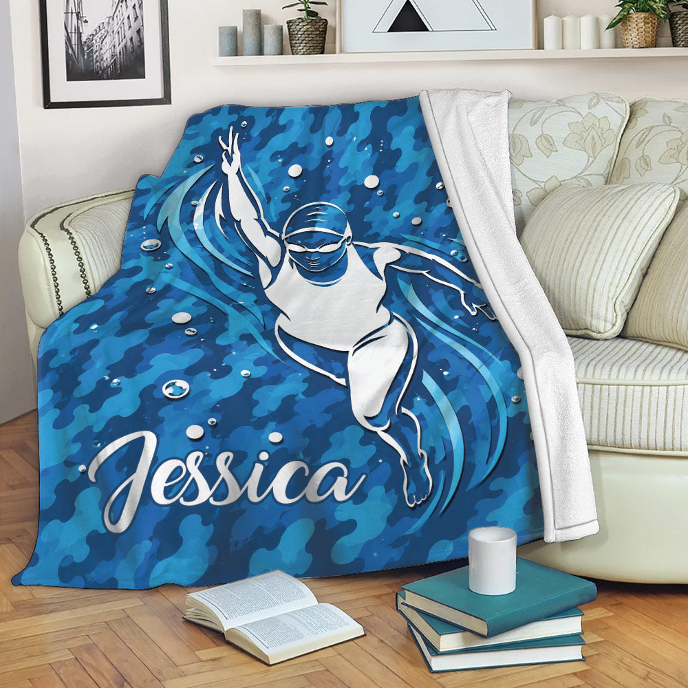 Swimming throw blanket displayed on a sofa with blue underwater swimmer artwork